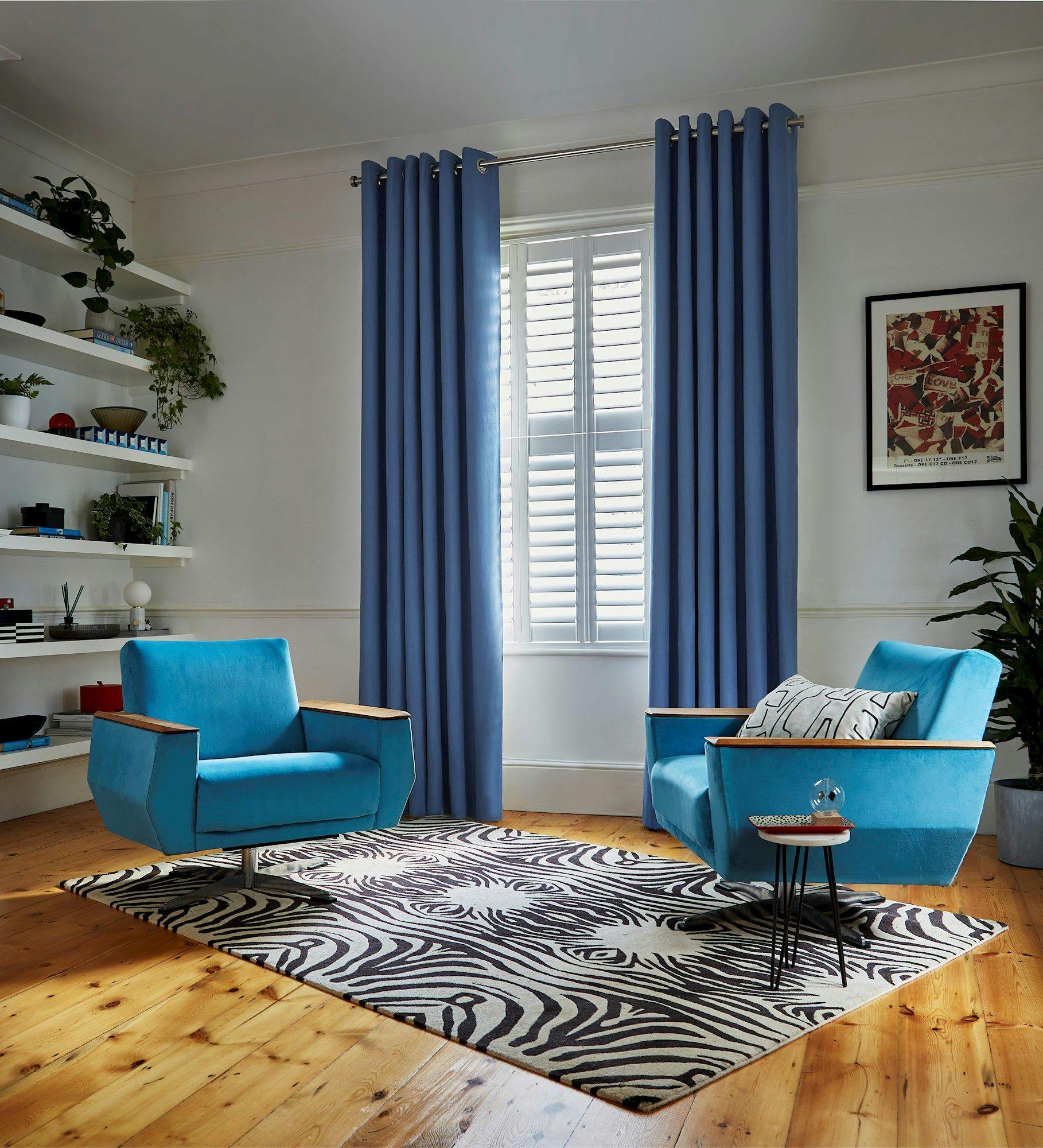 Faso cornflower blue eyelet curtains paired with white shutters in living room