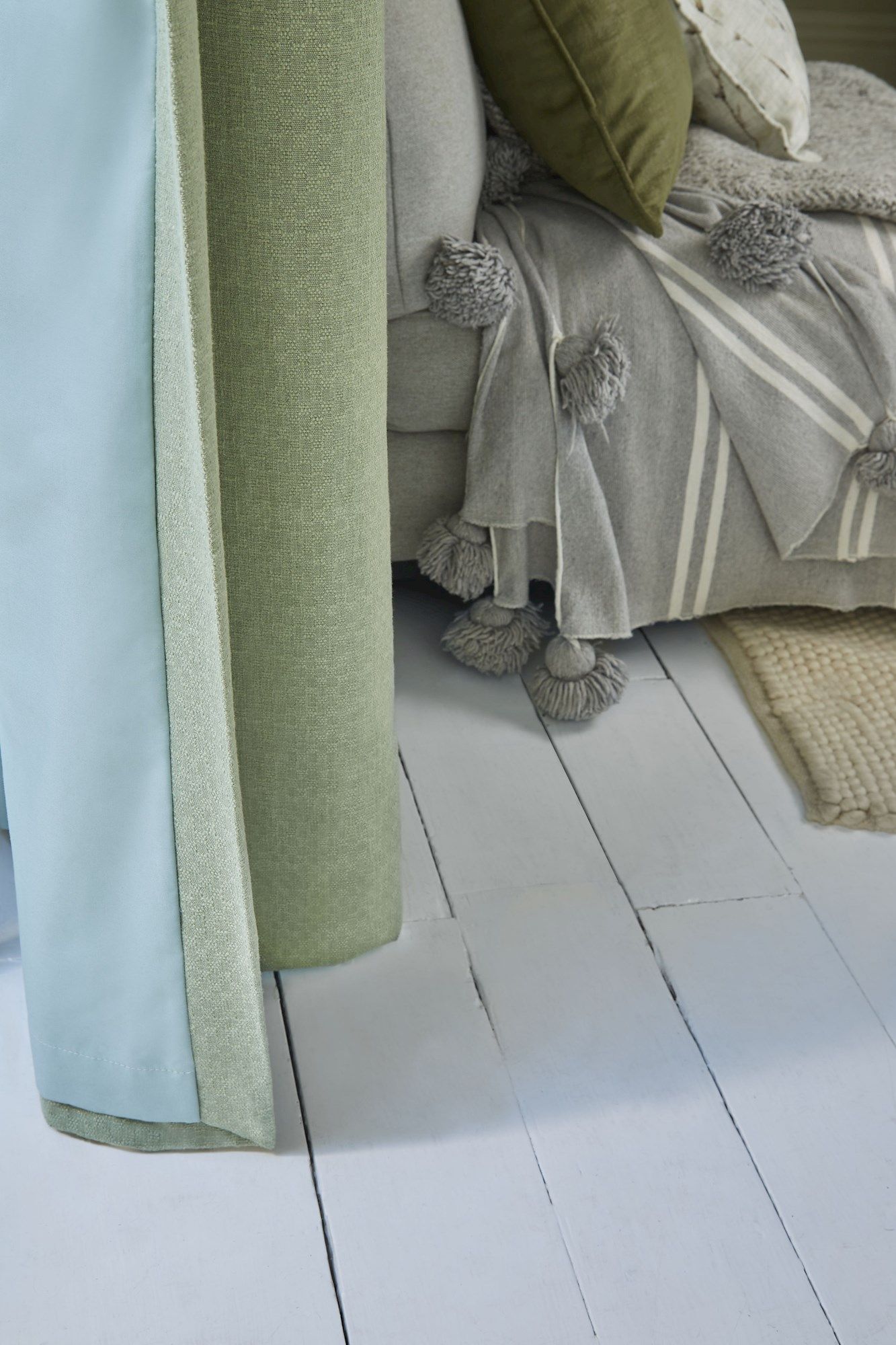 Pearl olive green floor length pinch pleat curtains paired with voiles in cosy living room