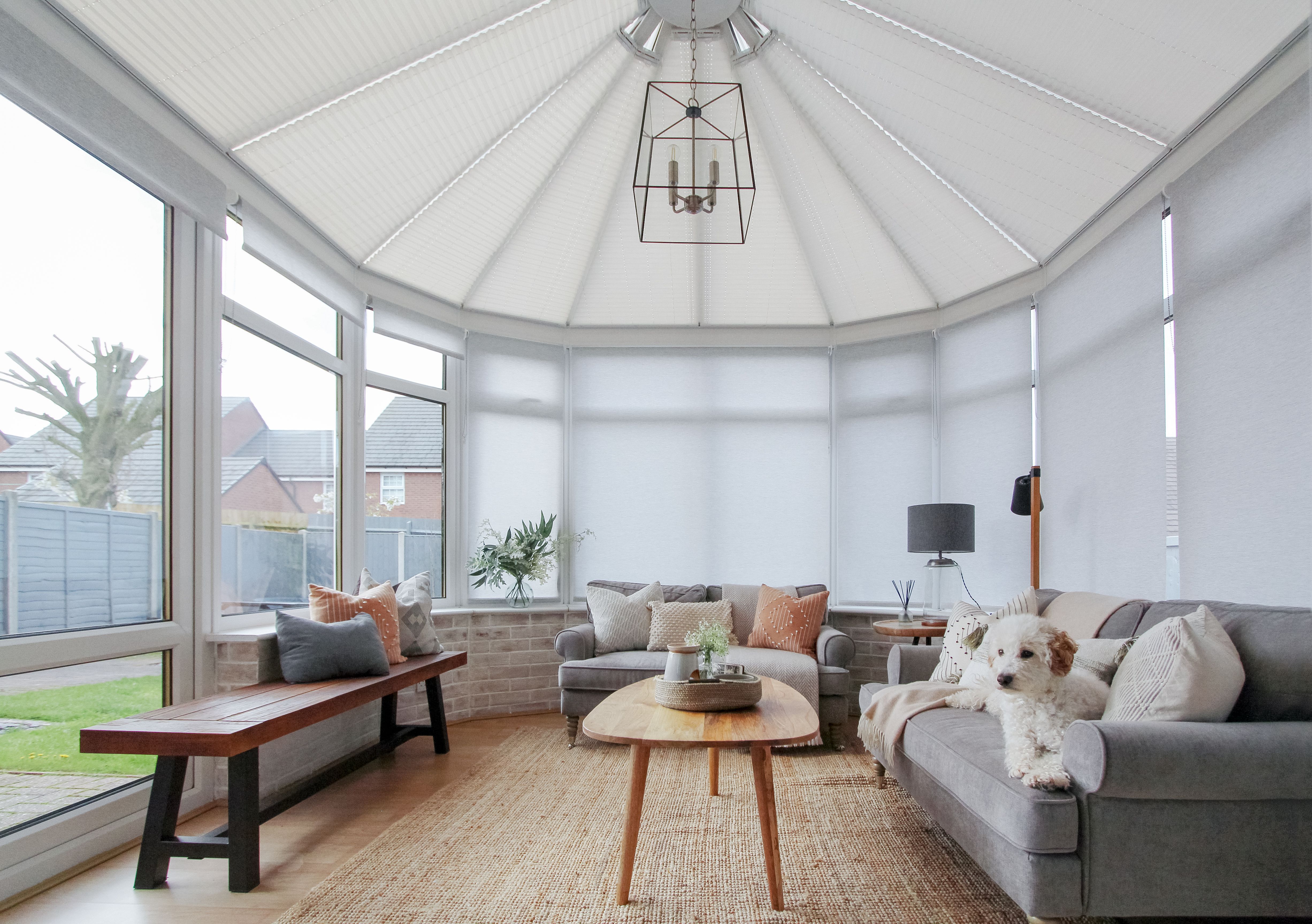 side conservatory roller blinds paired with white pleated roof blinds in large circular conservatory