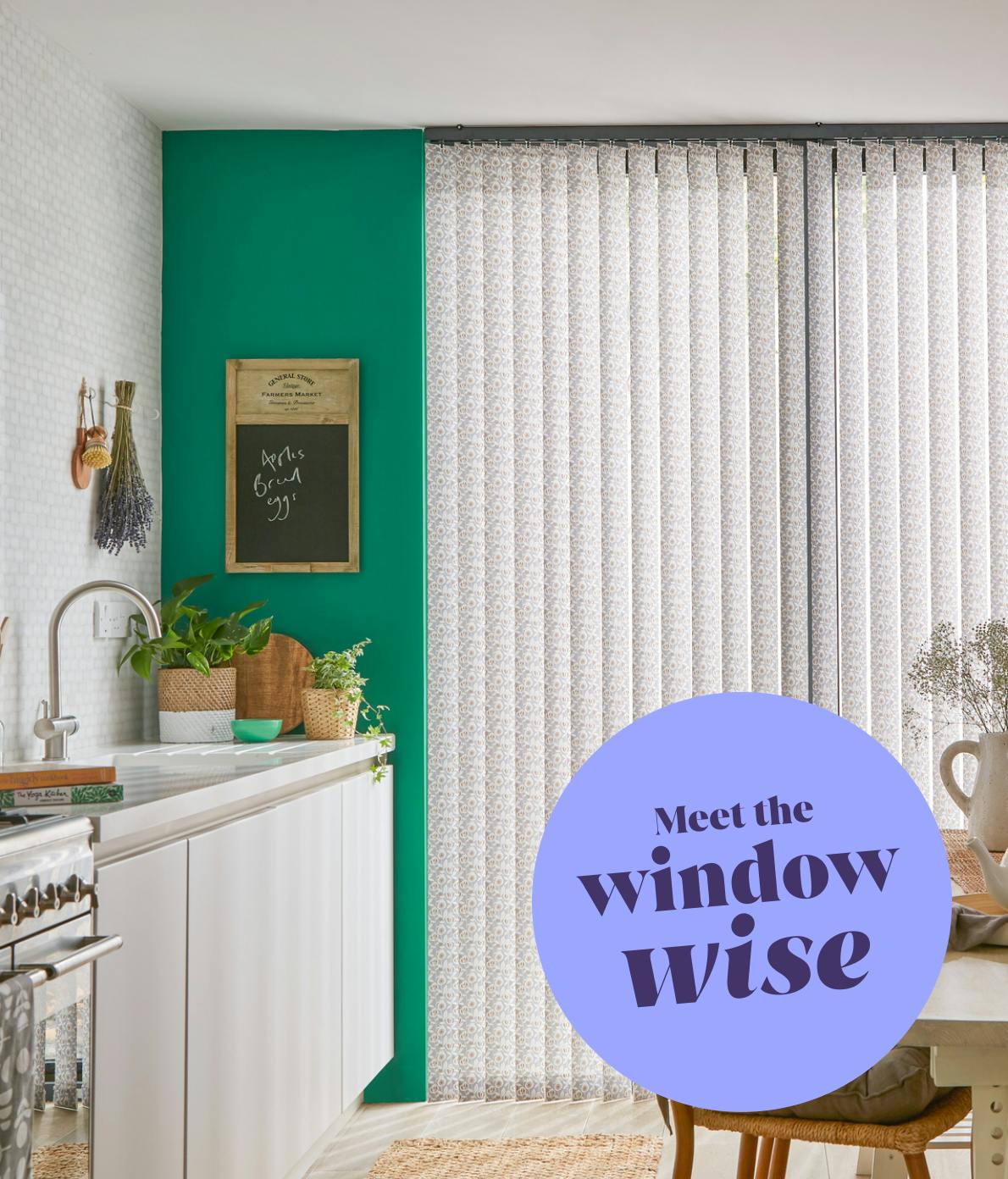 Vertical blinds cover a bright window in a kitchen with white cabinets, plants, and a chalkboard. Text on the image reads, "Meet the window wise."