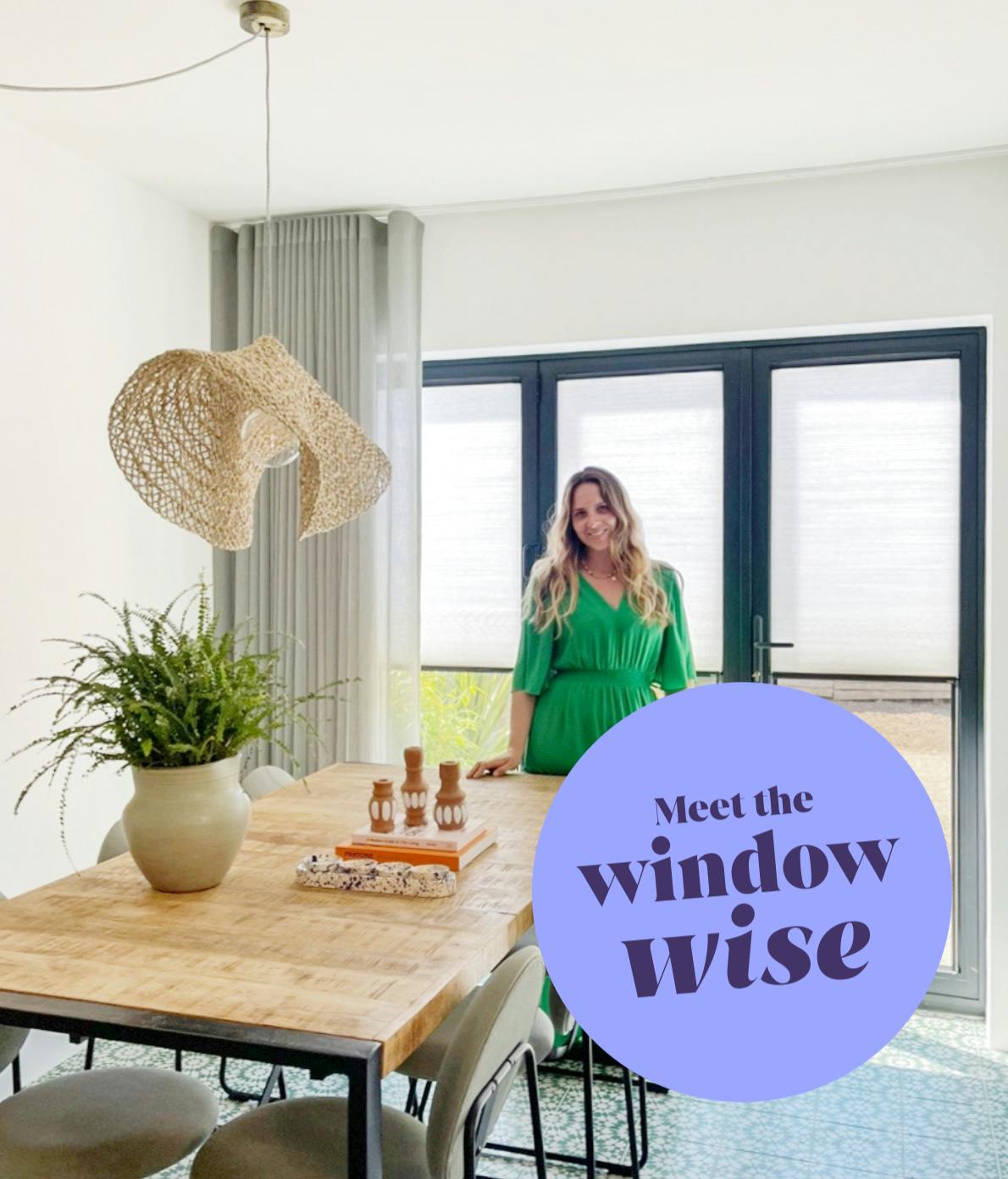 A woman in a green dress stands beside a wooden dining table with a plant and candles, under a woven light fixture. Text reads, "Meet the window wise."