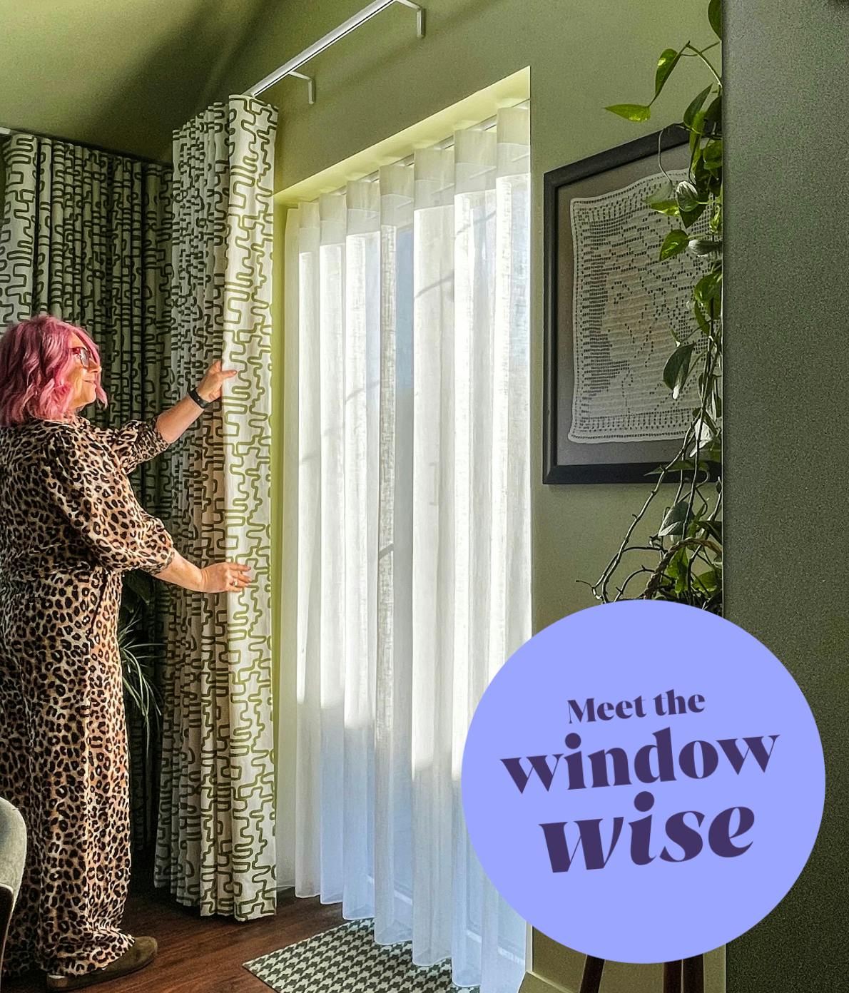 A person adjusts patterned drapes next to sheer curtains in a sunlit room with green walls and a potted plant. Text reads: "Meet the window wise."