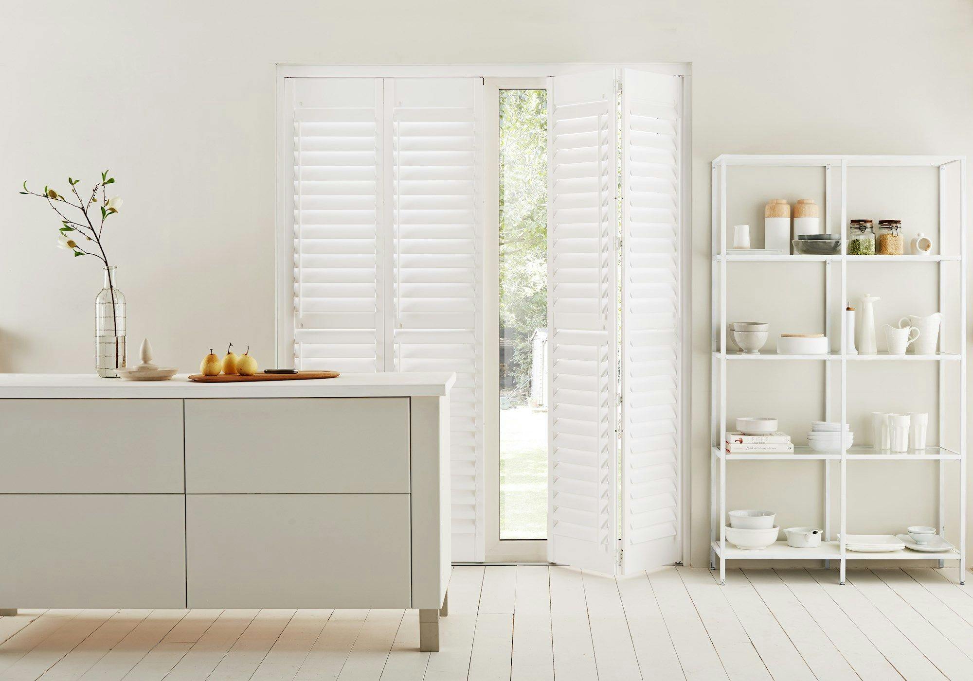 Pure white tracked shutters on door in kitchen dining room
