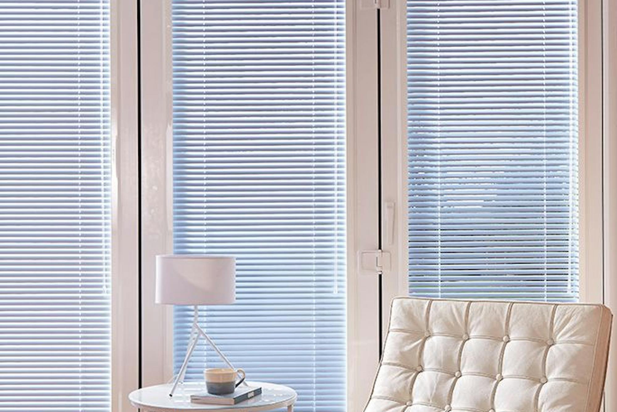 Living room lounge chair next to bifold doors with blue perfect blinds