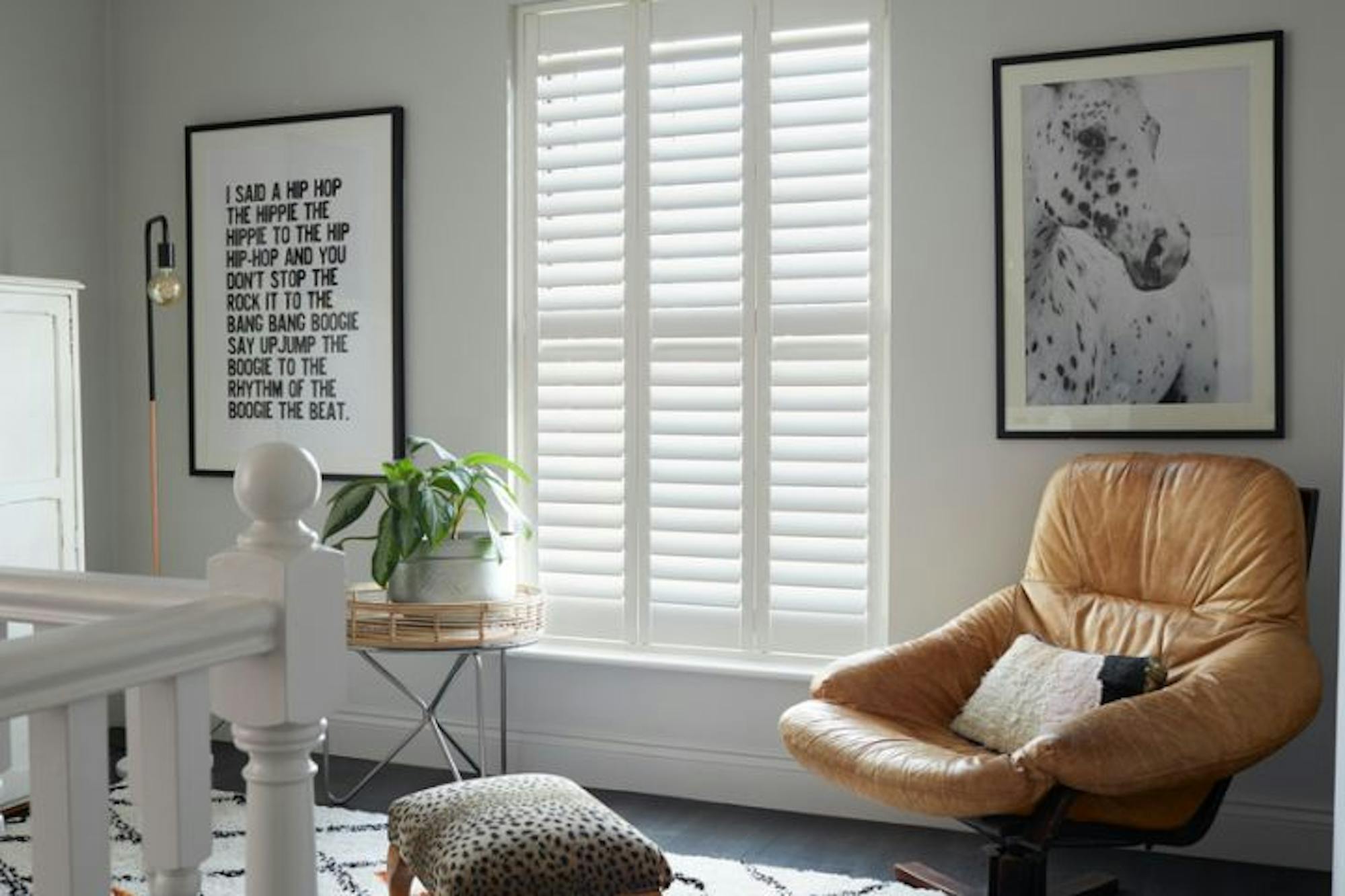 full height silk white shutters made of richmond material installed on windows of wall in hallway