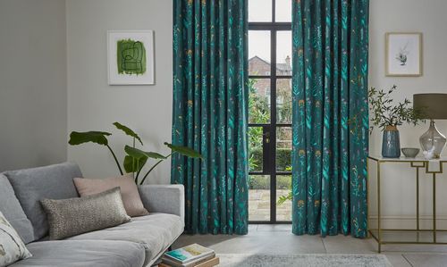 Teal patterned curtains covering large glass patio doors