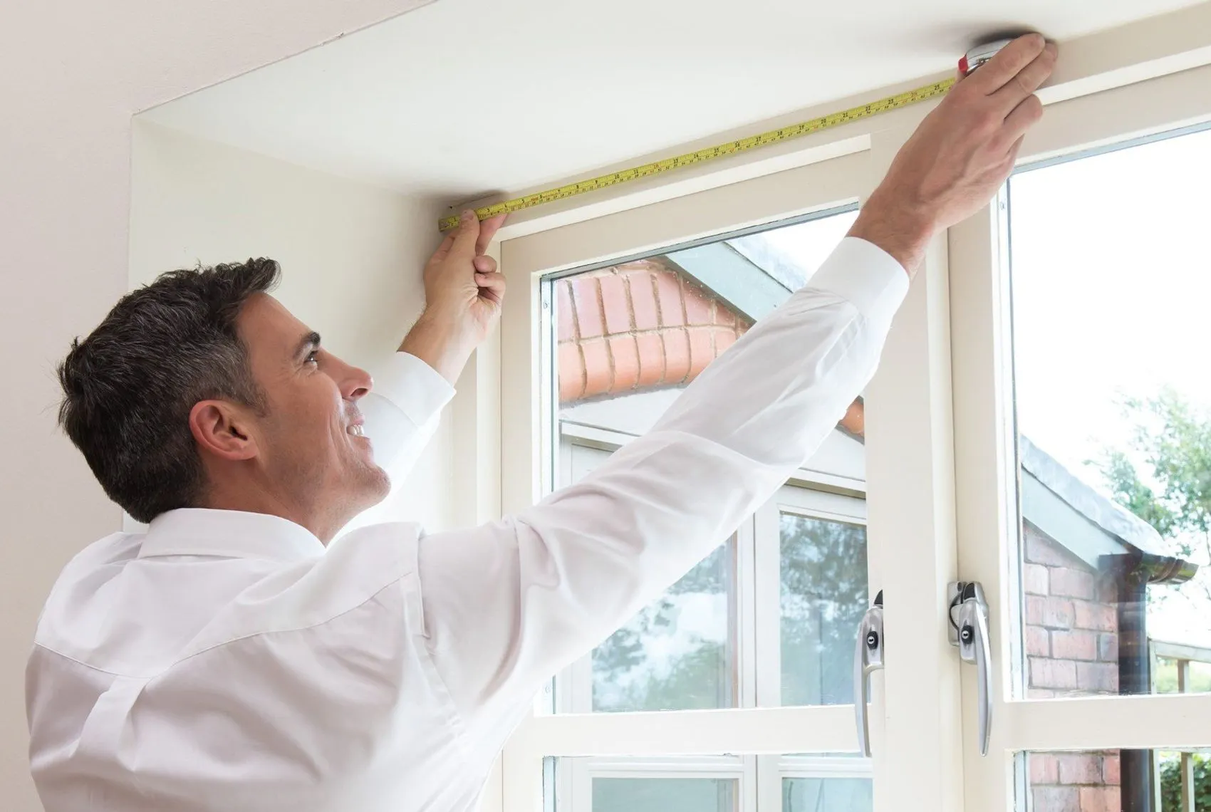 Hillarys advisor measuring window during an appointment in customer's home