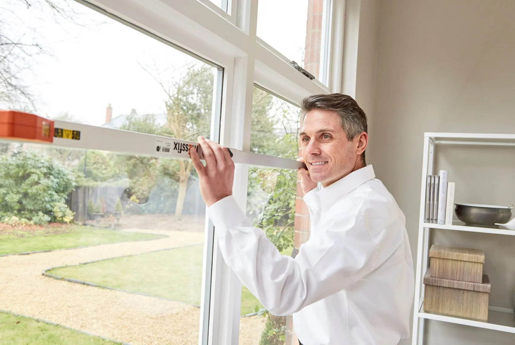 Friendly Hillarys advisor measuring a window during an appointment in customer's home 