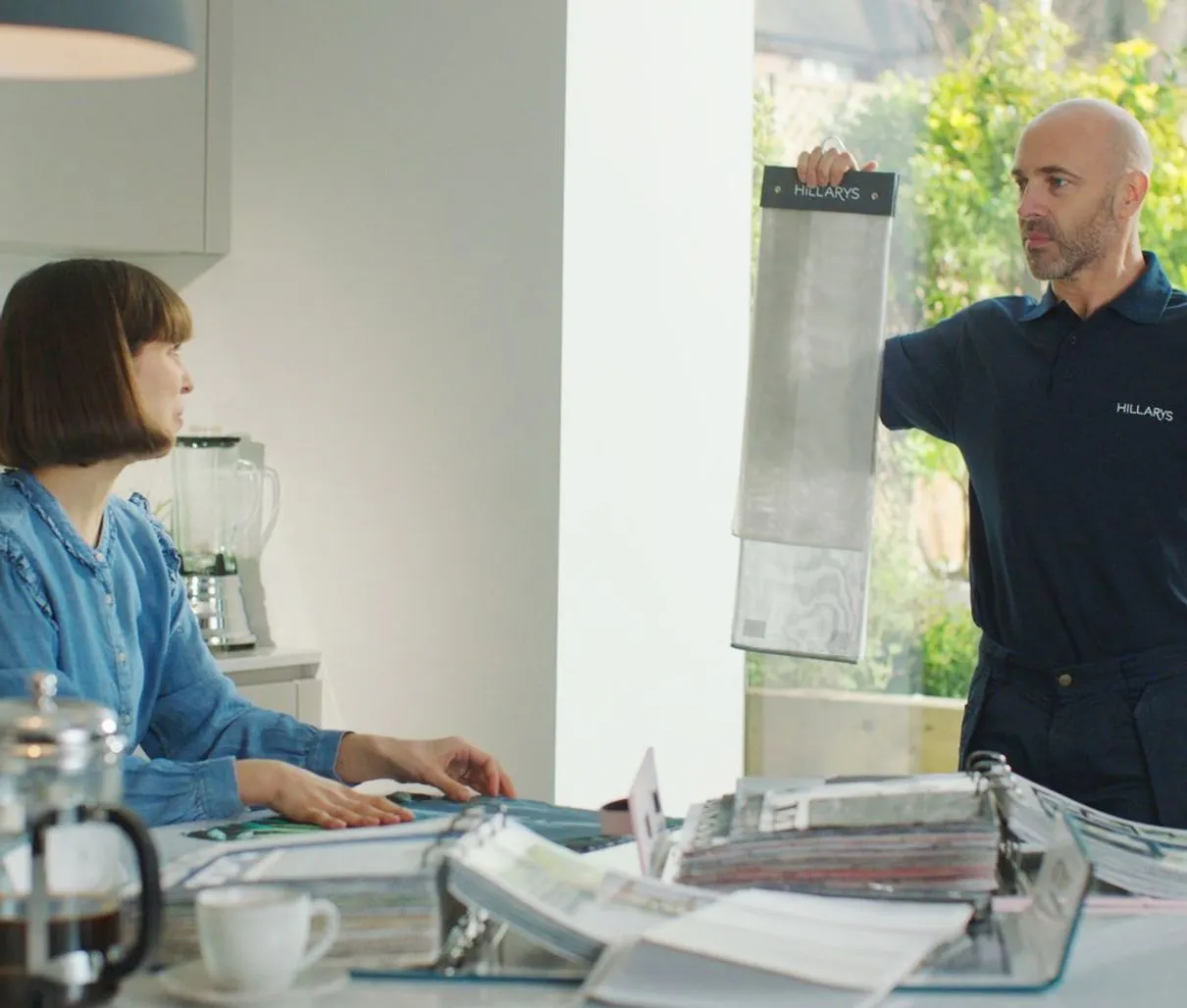 Friendly Hillarys advisor showing fabric samples to a customer at home