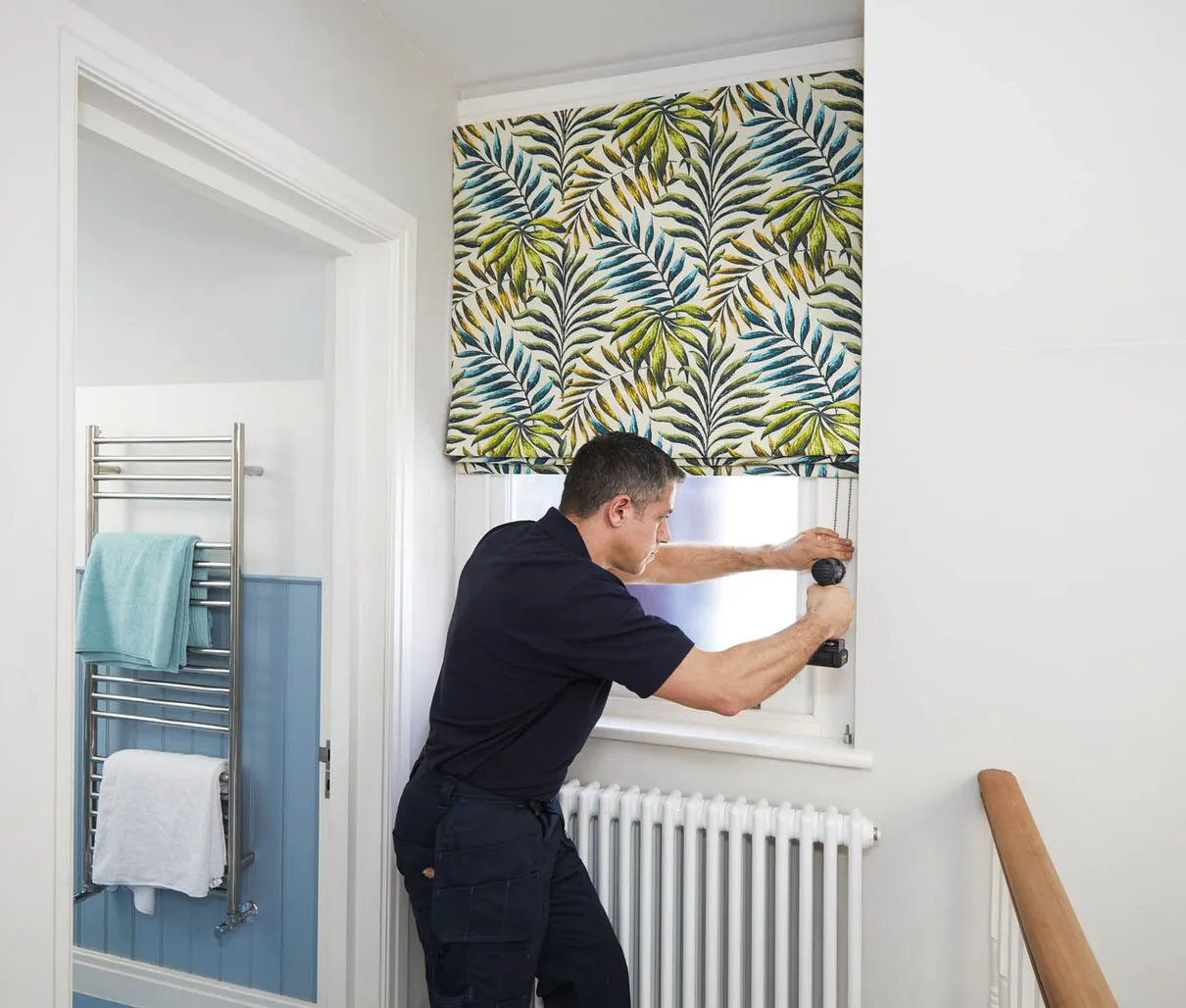 Hillarys advisor installing roller blinds on a window in customer's home