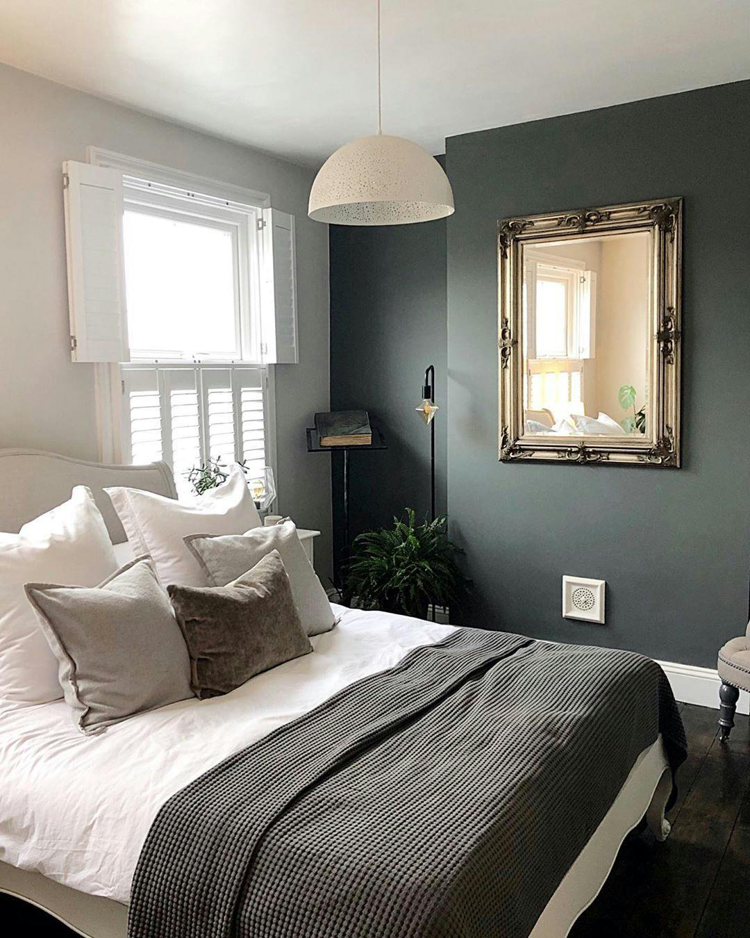 windows dressed with white shutters in a bedroom with a white bed