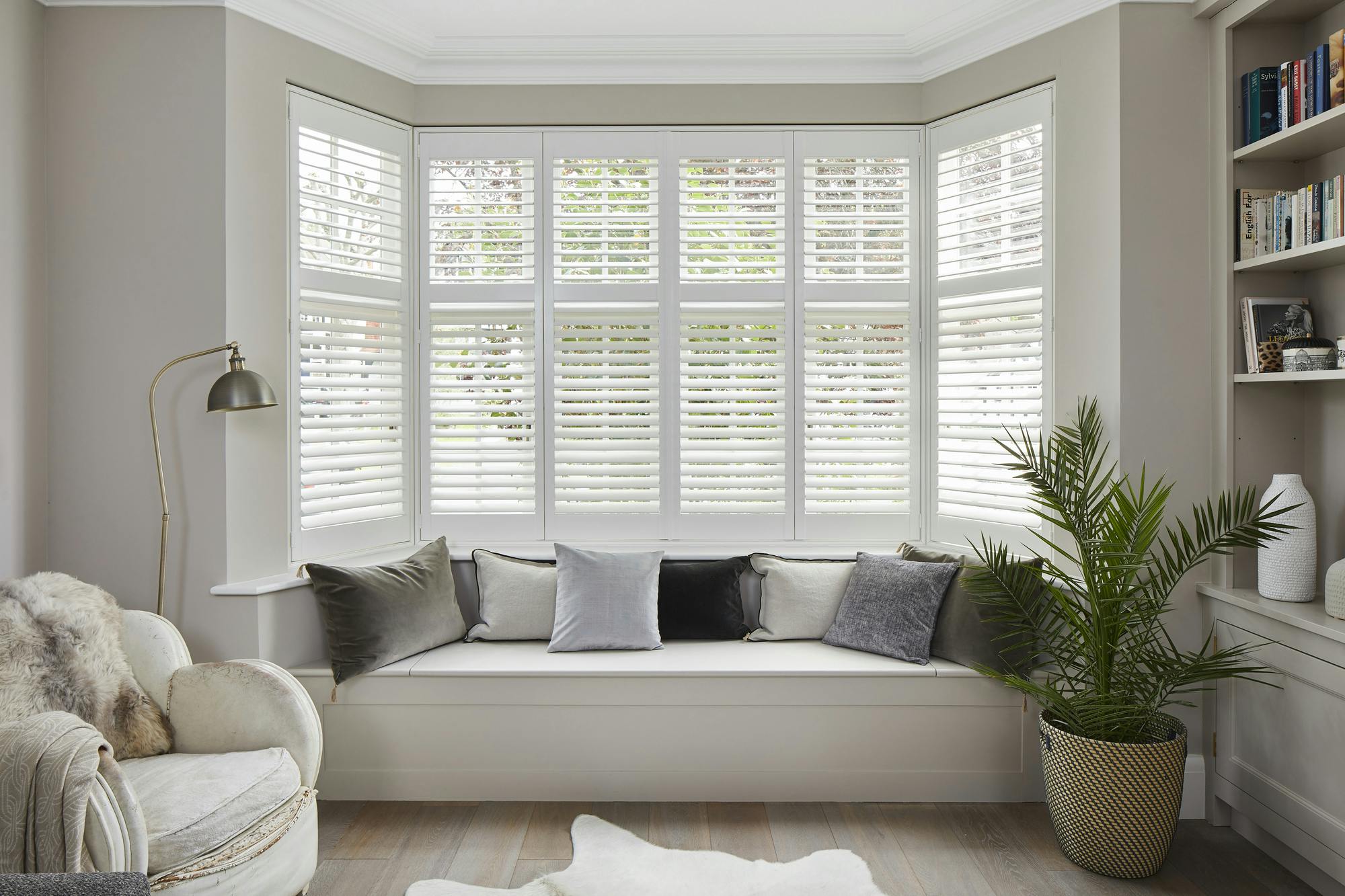 A bay window with white tier on tier shutters fitted to the window