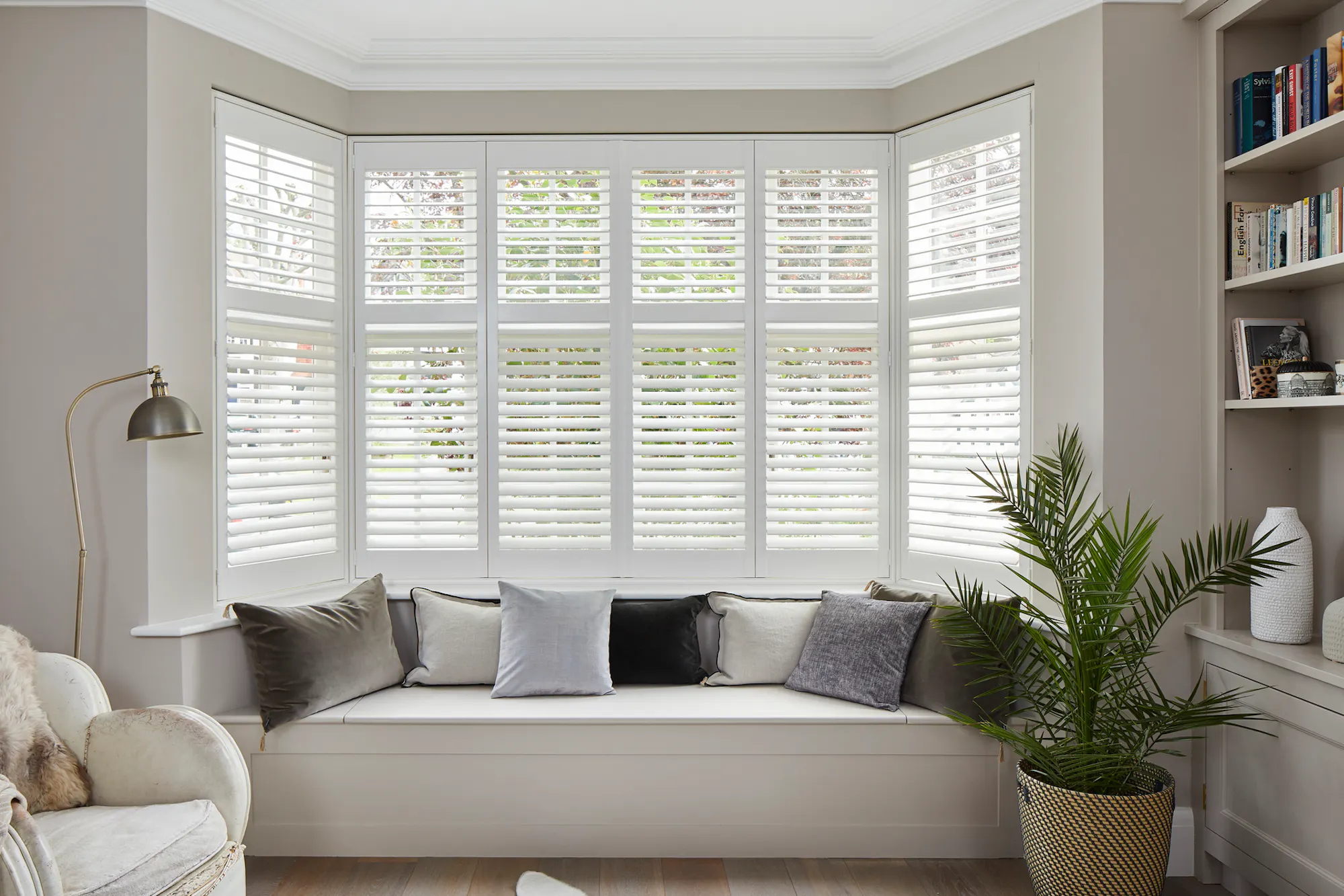 A bay window with white tier on tier shutters fitted to the window