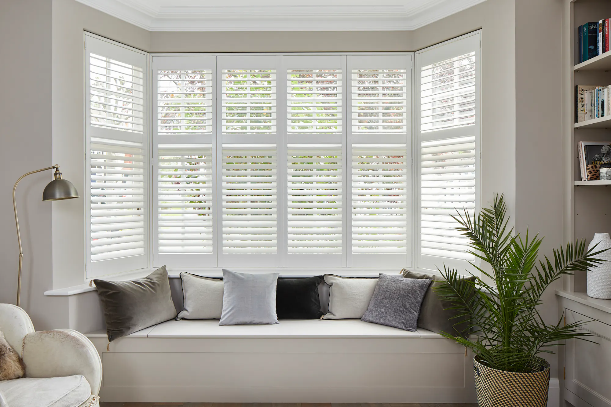 A bay window with white tier on tier shutters fitted to the window