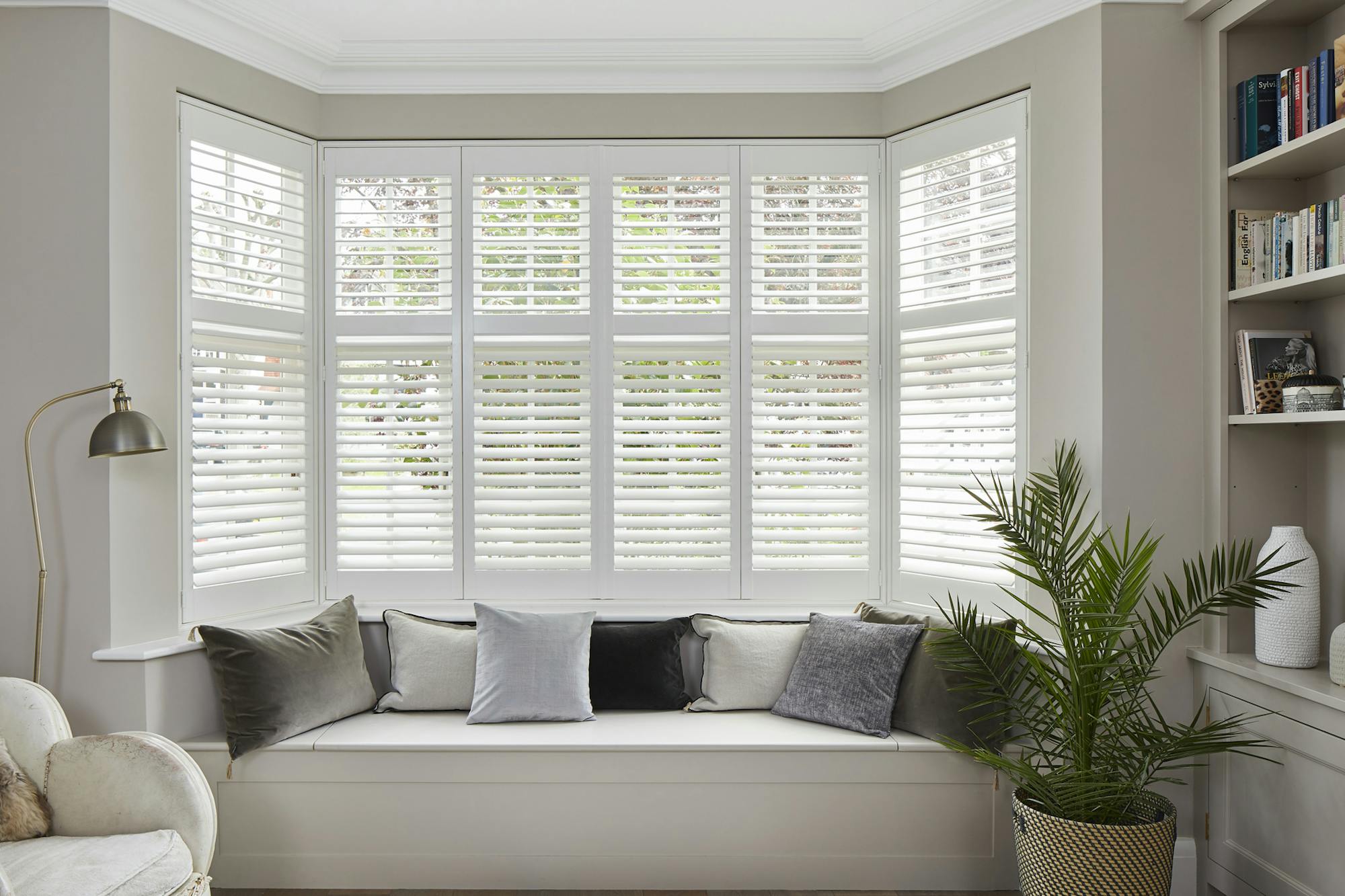 A bay window with white tier on tier shutters fitted to the window