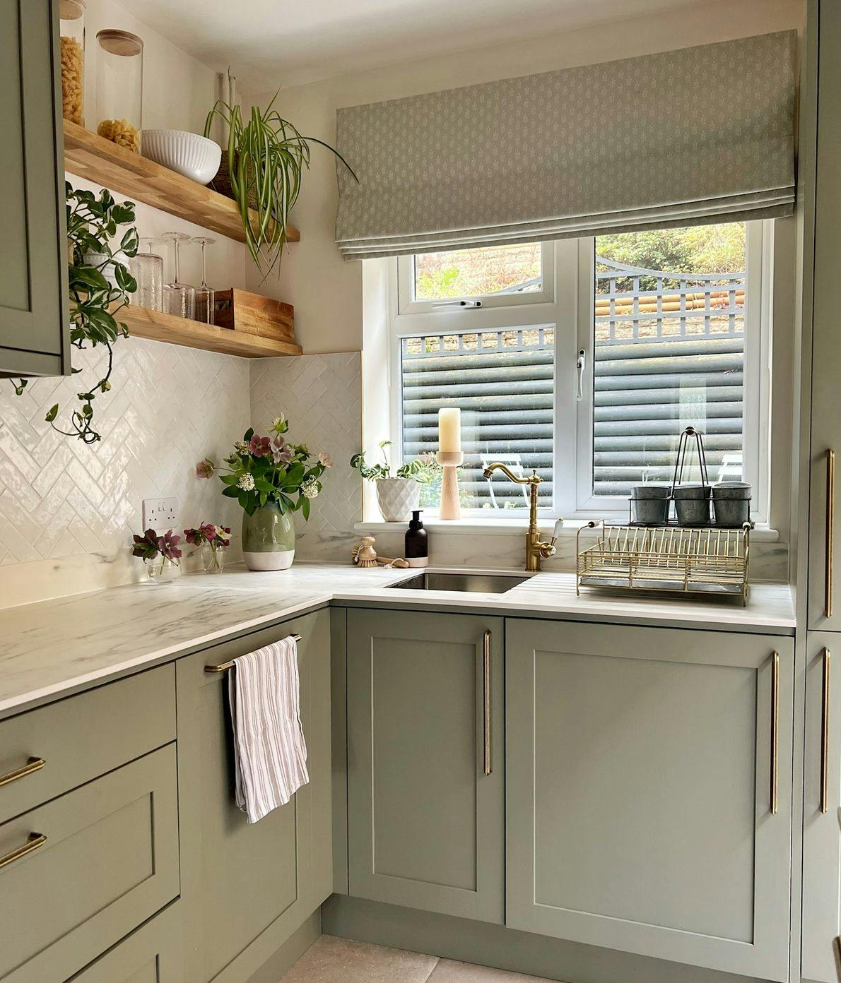 Bright cosy kitchen with opened beige Roman blinds on a window