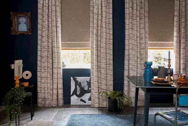 Modern dining room with patterned beige curtains and Roman blinds on windows
