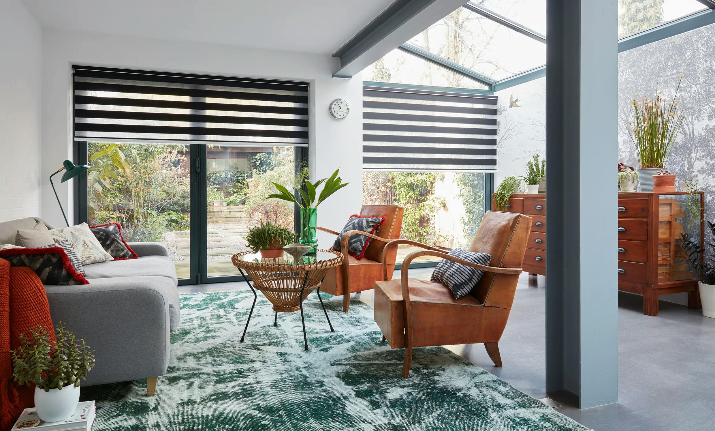Modern light living room with brown roller blinds on patio doors