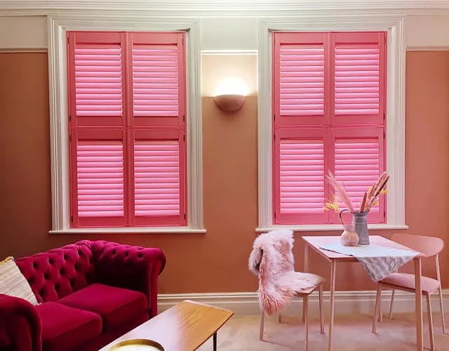 Modern living room with bright pink shutters on windows