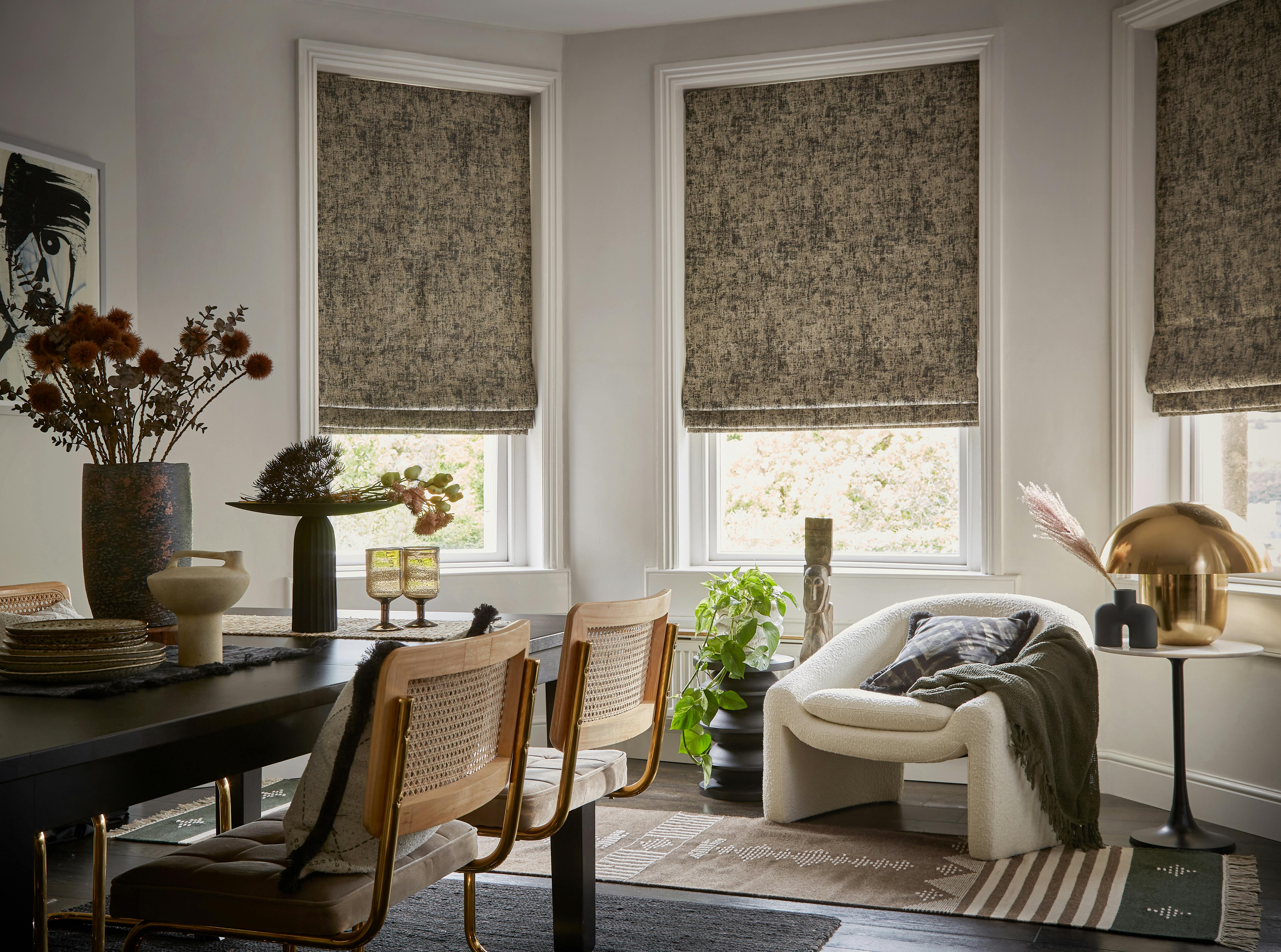 Garcia phantom roman blinds covering large dining room windows in a vintage style room.