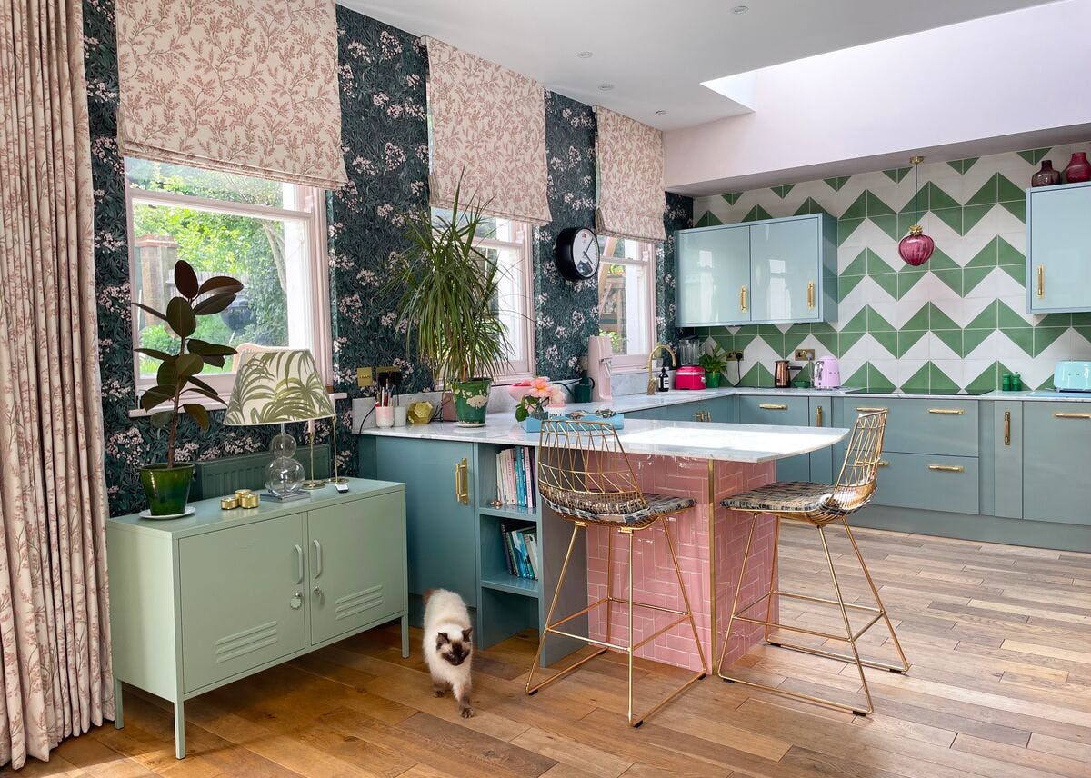 pink floral roman blind and curtain in kitchen/living area with floral patterned walls and furnishings