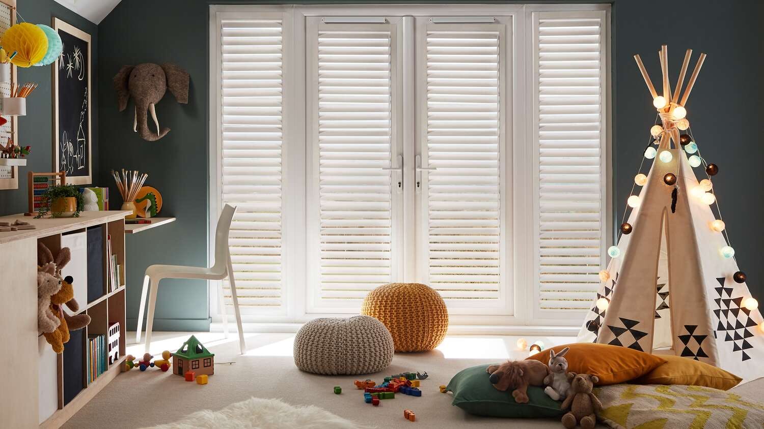 Children’s room with full‑height white shuttered doors, teal walls and soft neutral tones with playful décor.