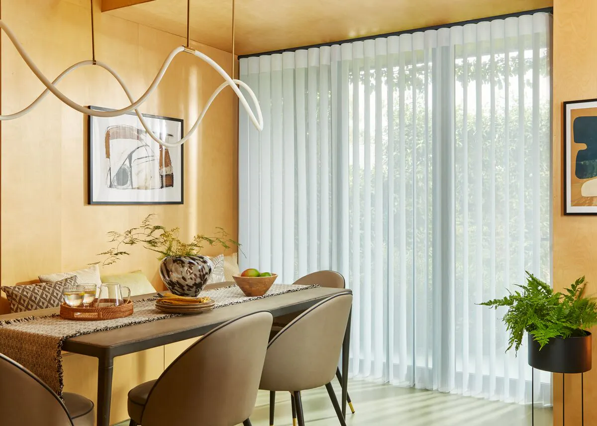 Bright dining room with floor-to-ceiling window dressed in Diffused blinds, letting soft daylight wash over a modern table and chairs.
