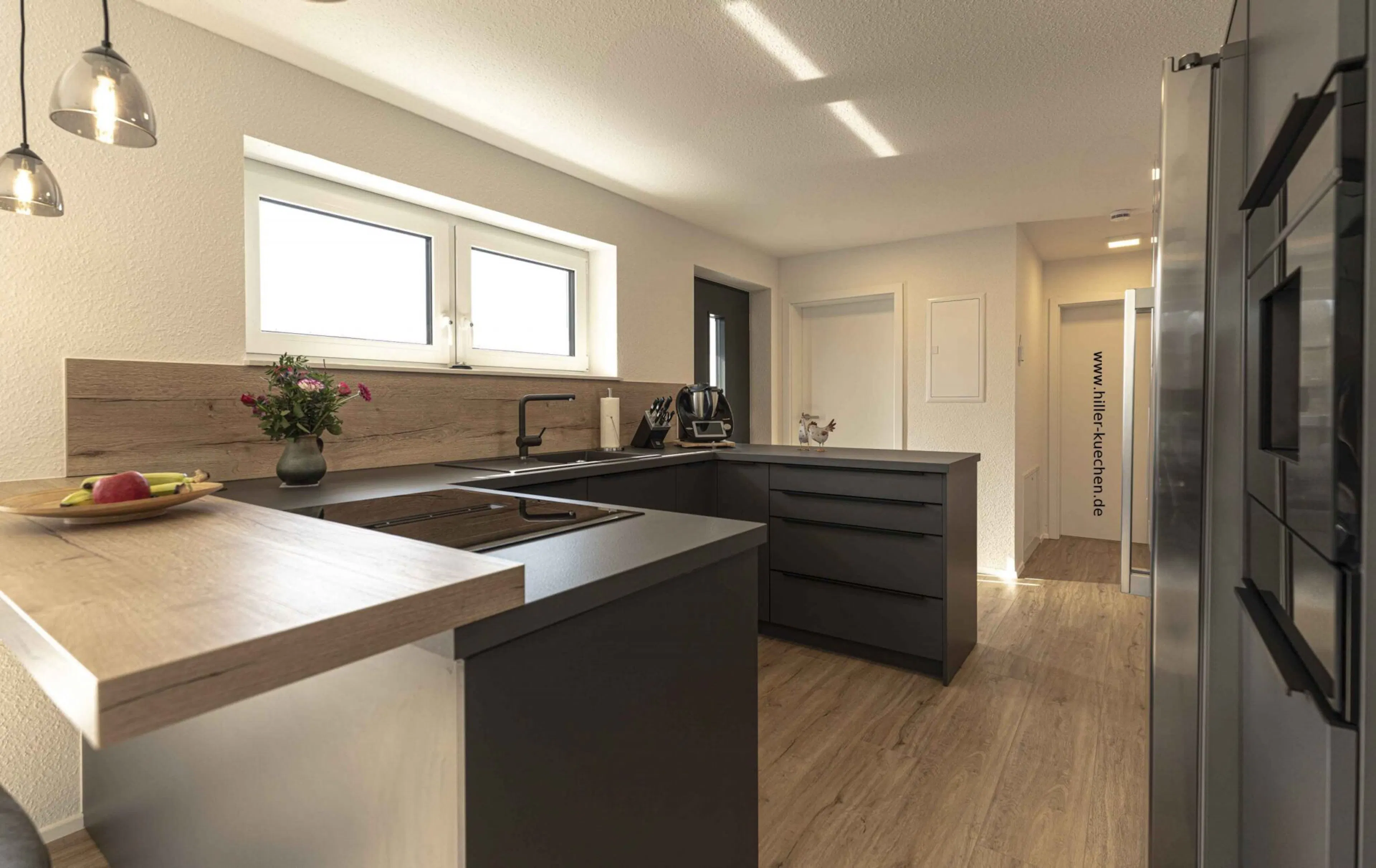 Referenz Hiller Küchenstudio: Anthrazitfarbene Einbauküche mit massiver Holz-Theke und passender Rückwand in Nordheim.