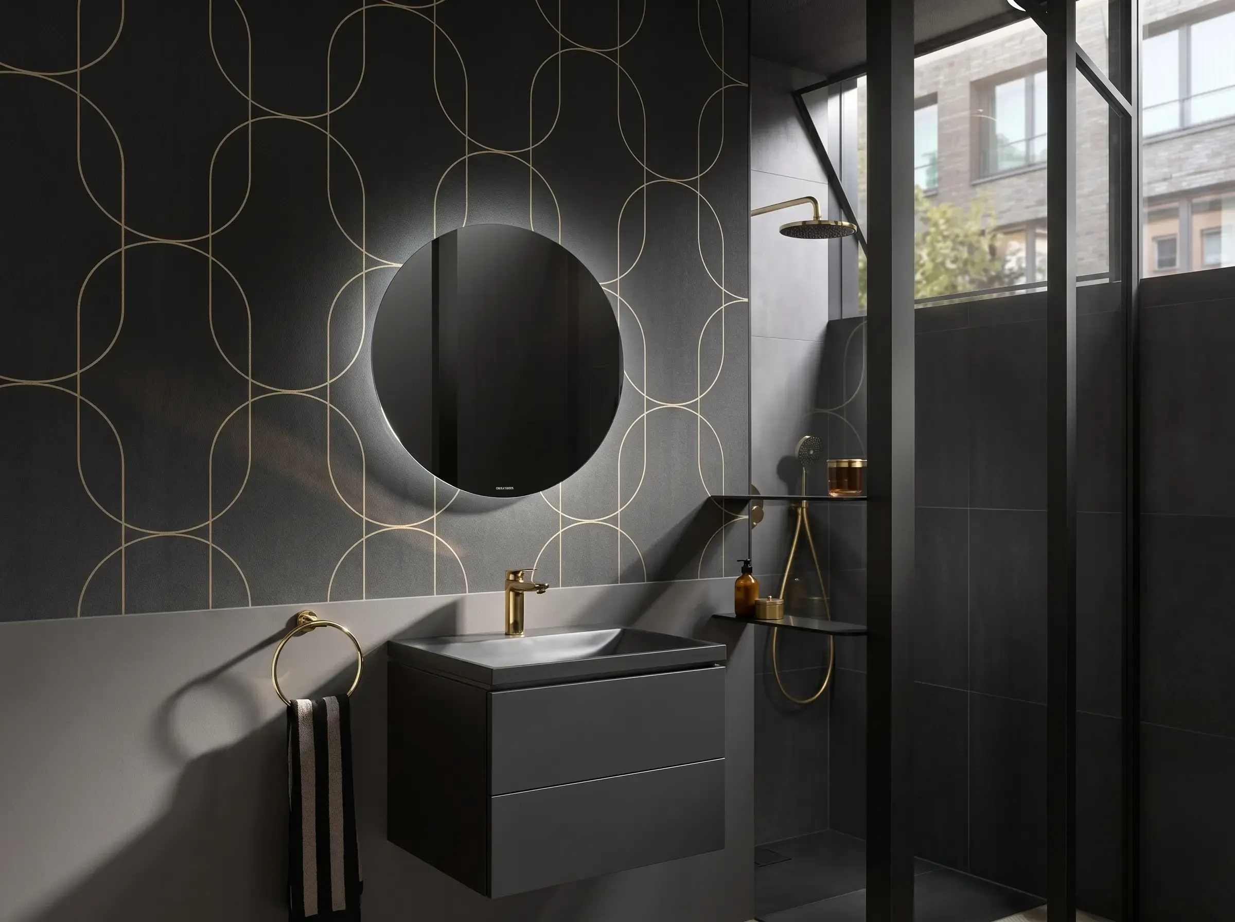 Exklusives Designerbad von Walther Sanitär: Dunkler Waschtisch mit Gold-Armaturen und hinterleuchtetem Rundspiegel.