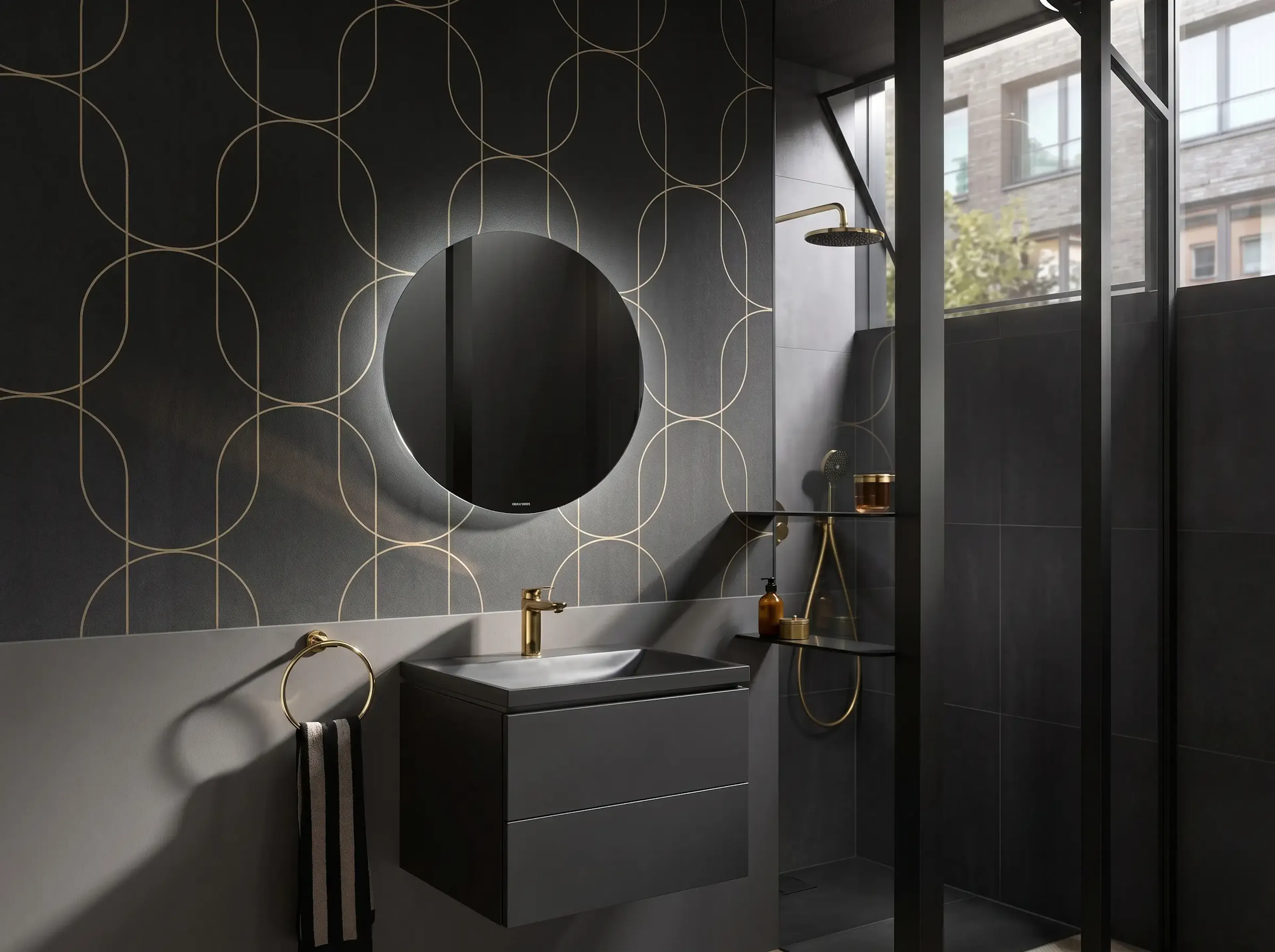 Exklusives Designerbad von Walther Sanitär: Dunkler Waschtisch mit Gold-Armaturen und hinterleuchtetem Rundspiegel.