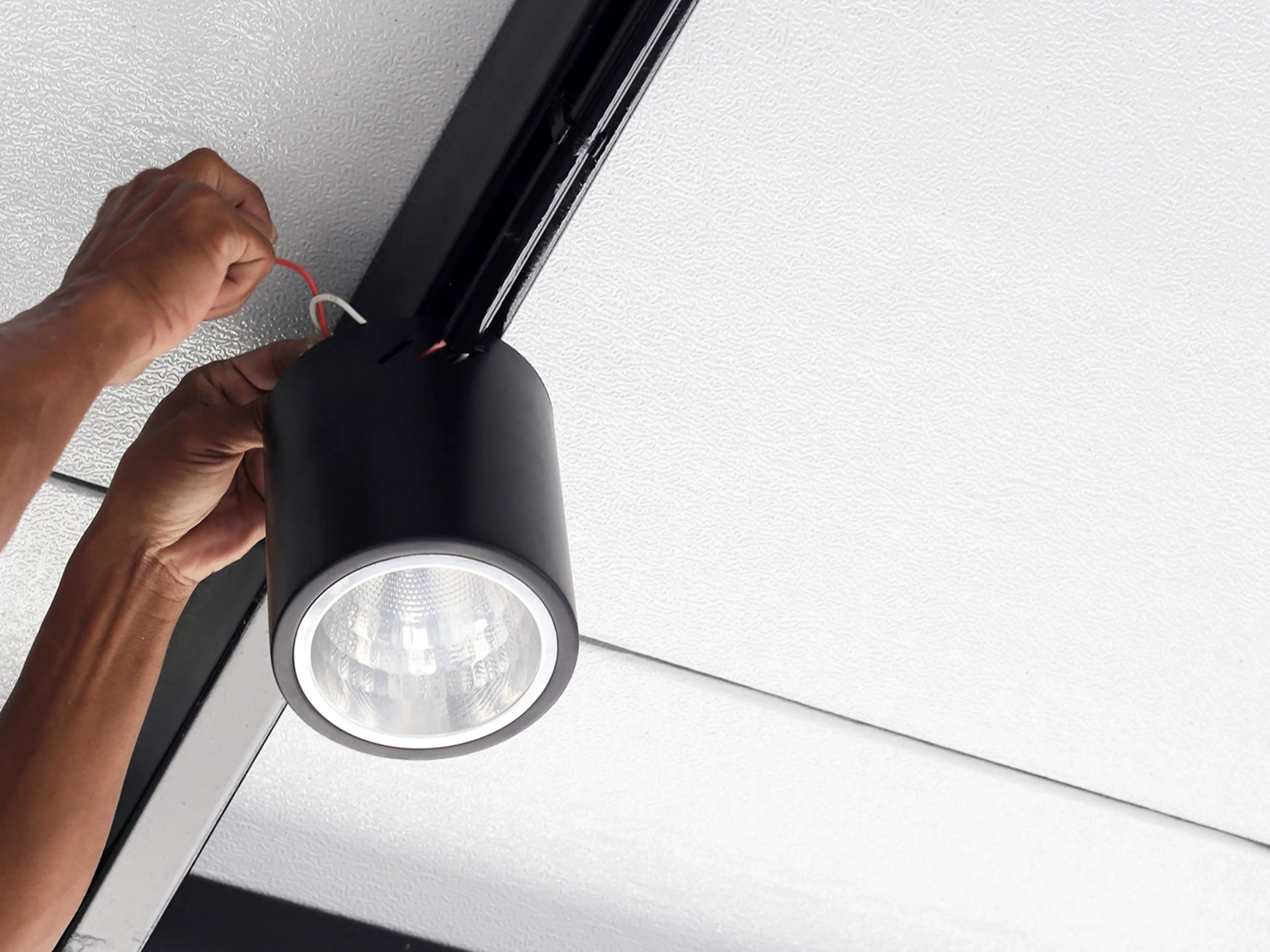 Fachmännische Elektroinstallation einer LED-Deckenleuchte im Rahmen der modernen technischen Gebäudeausstattung.