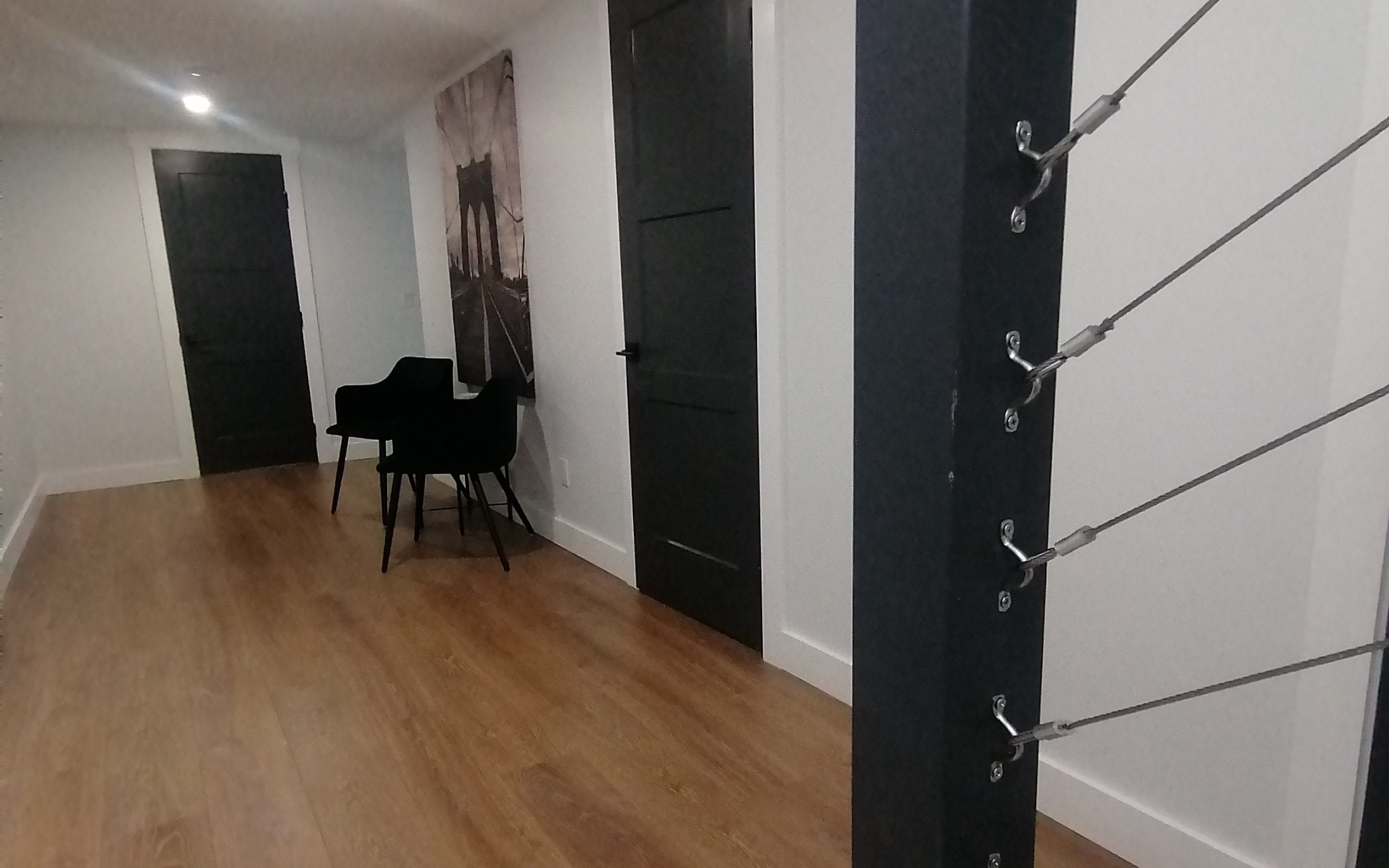 Designer stairwell leading to an open hallway with wood floor - Hint of Honey