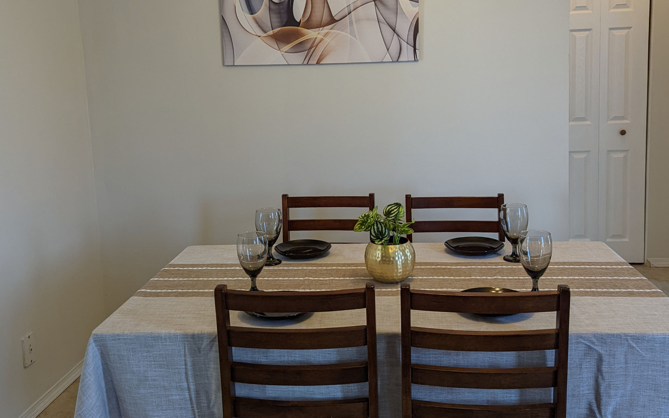 Staged dining room table with wooden chairs and fine dinnerware - Hint of Honey