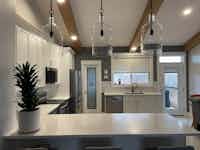 Modern kitchen with wood accents and chic lighting - Hint of Honey Fort St John
