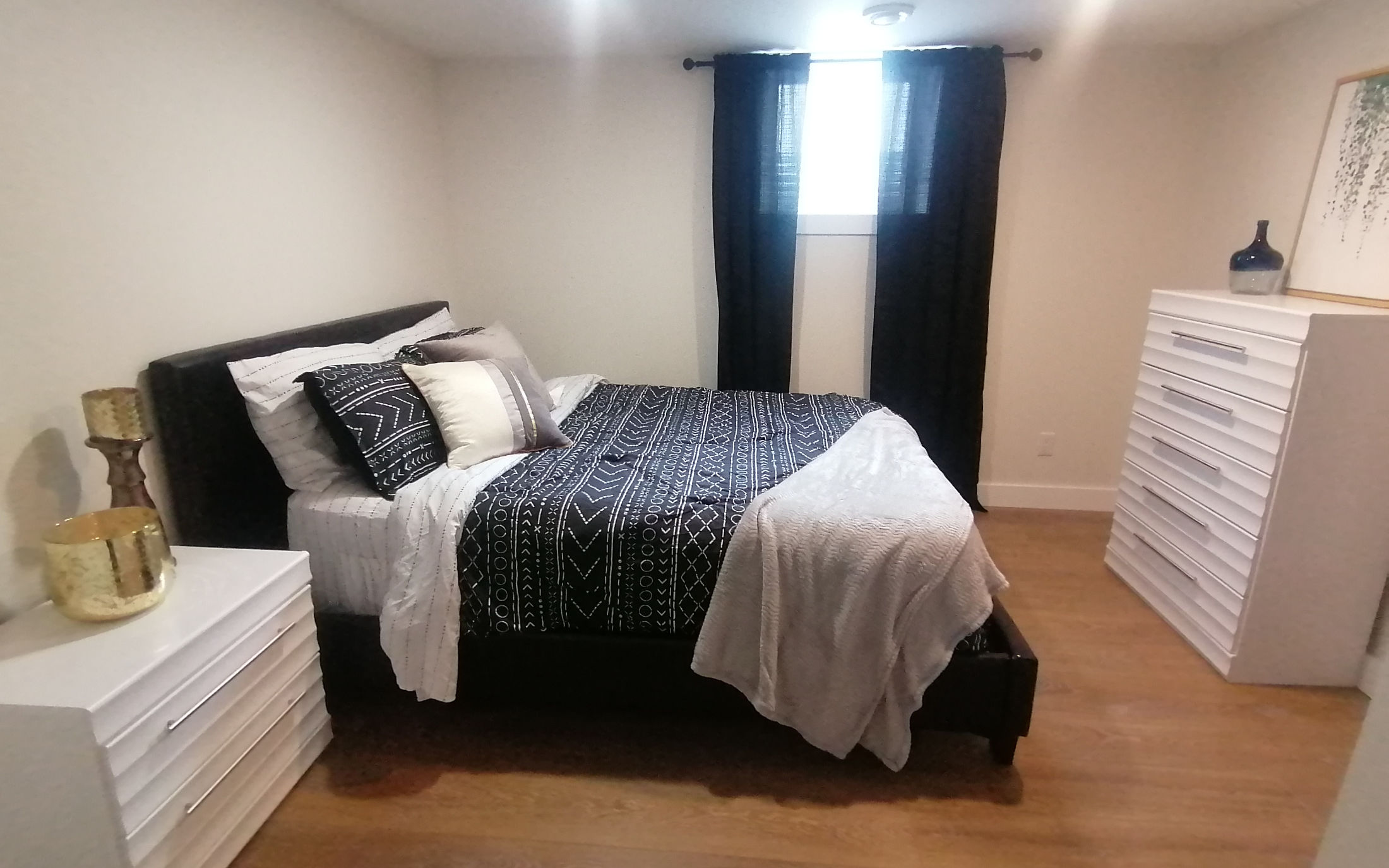 Modern bedroom with chic white dressers and black accents - Hint of Honey
