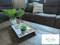 Staged living room with comfortable pillows and green plants, home staging by Hint of Honey
