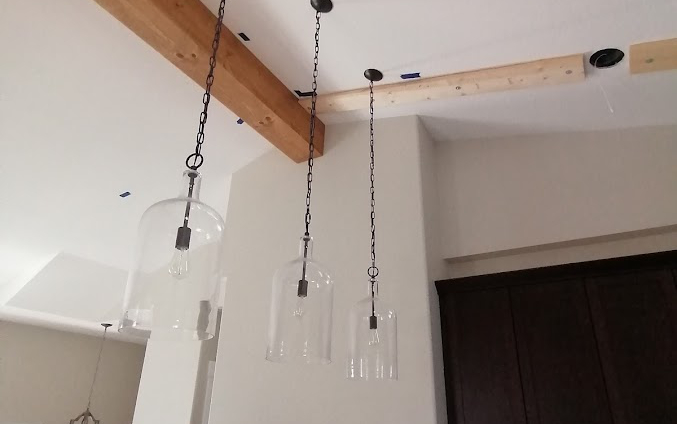 Custom wood beams and chic lighting in kitchen - Hint of Honey interior design