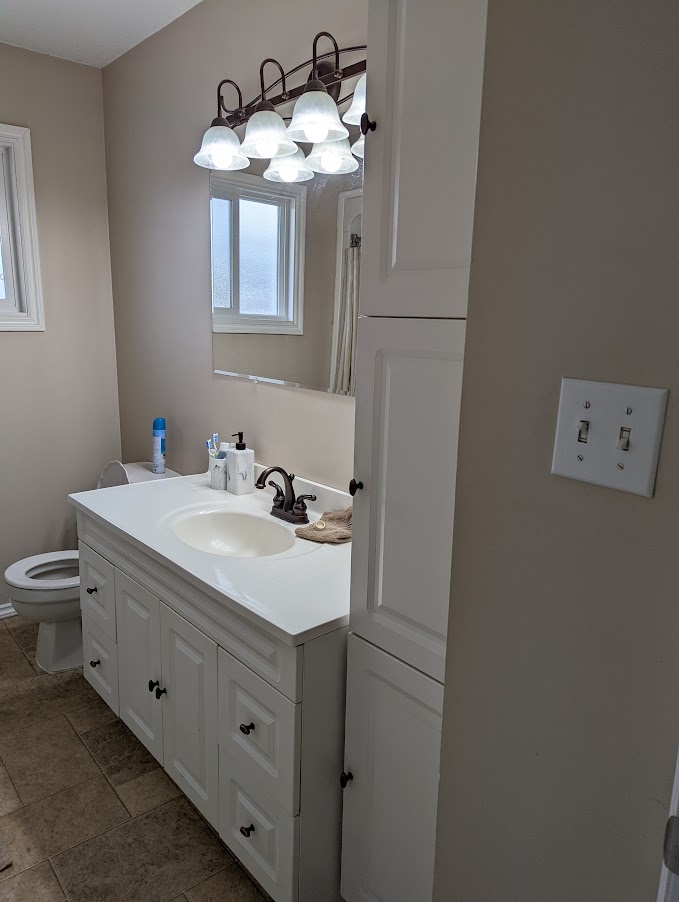 Bathroom with white cabinetry before renovation by Hint of Honey