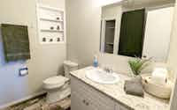 Downstairs staged bathroom with soap, towels, and accessories - Hint of Honey