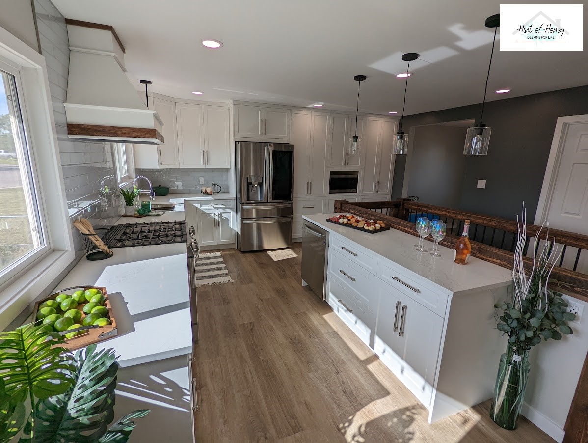 Looking into a spacious kitchen with white countertops and stainless appliances
