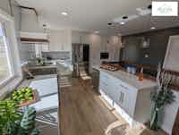 Looking into a spacious kitchen with white countertops and stainless appliances