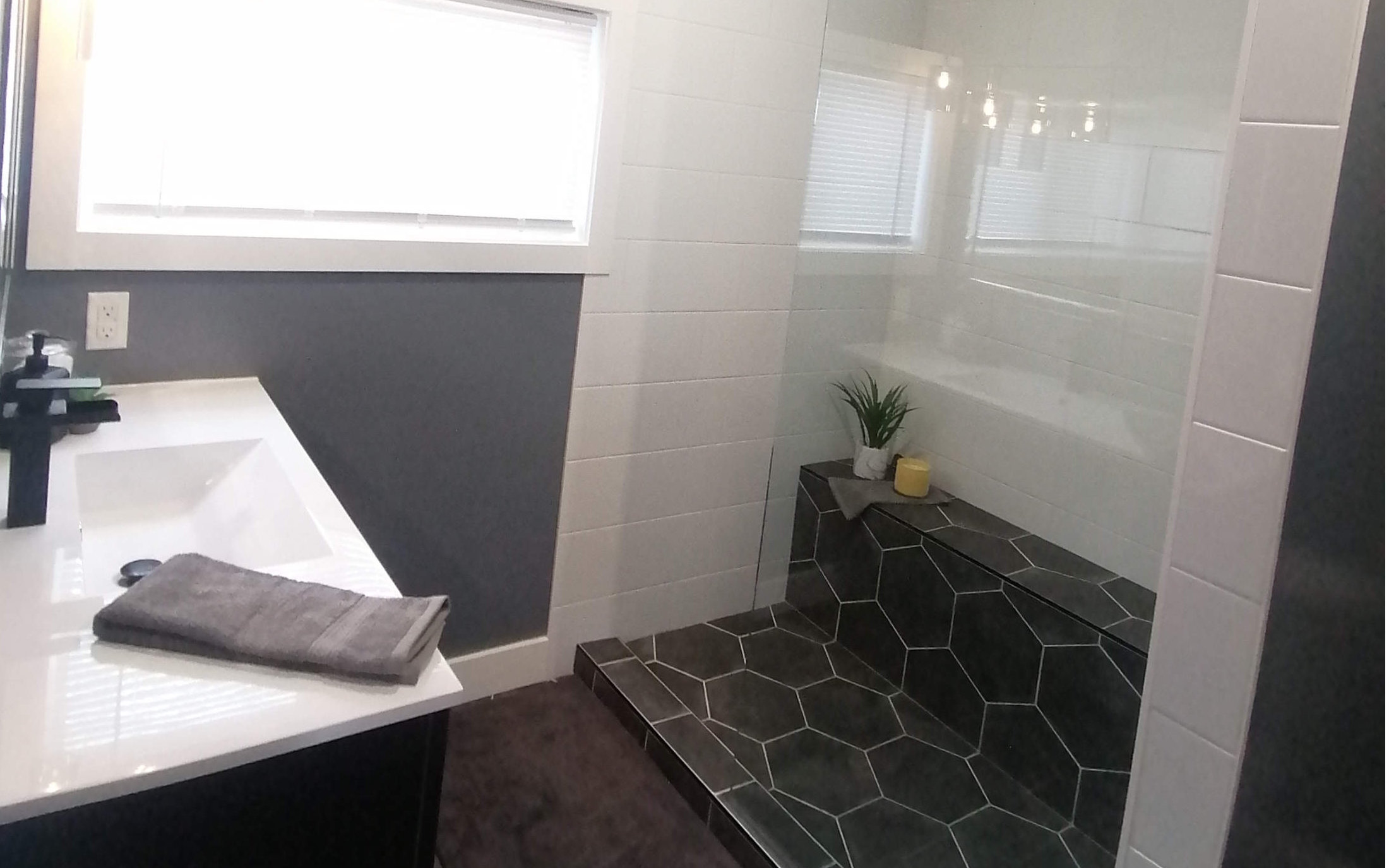 Custom bathroom design. Black tile floor and white shower tiles and sink