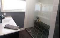 Custom bathroom design. Black tile floor and white shower tiles and sink