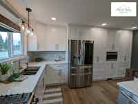 Modern kitchen with white cupboards and modern stainless steel appliances - designed by Hint of Honey