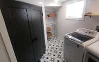 Designer laundry room with new appliances and sleek black doors - Hint of Honey