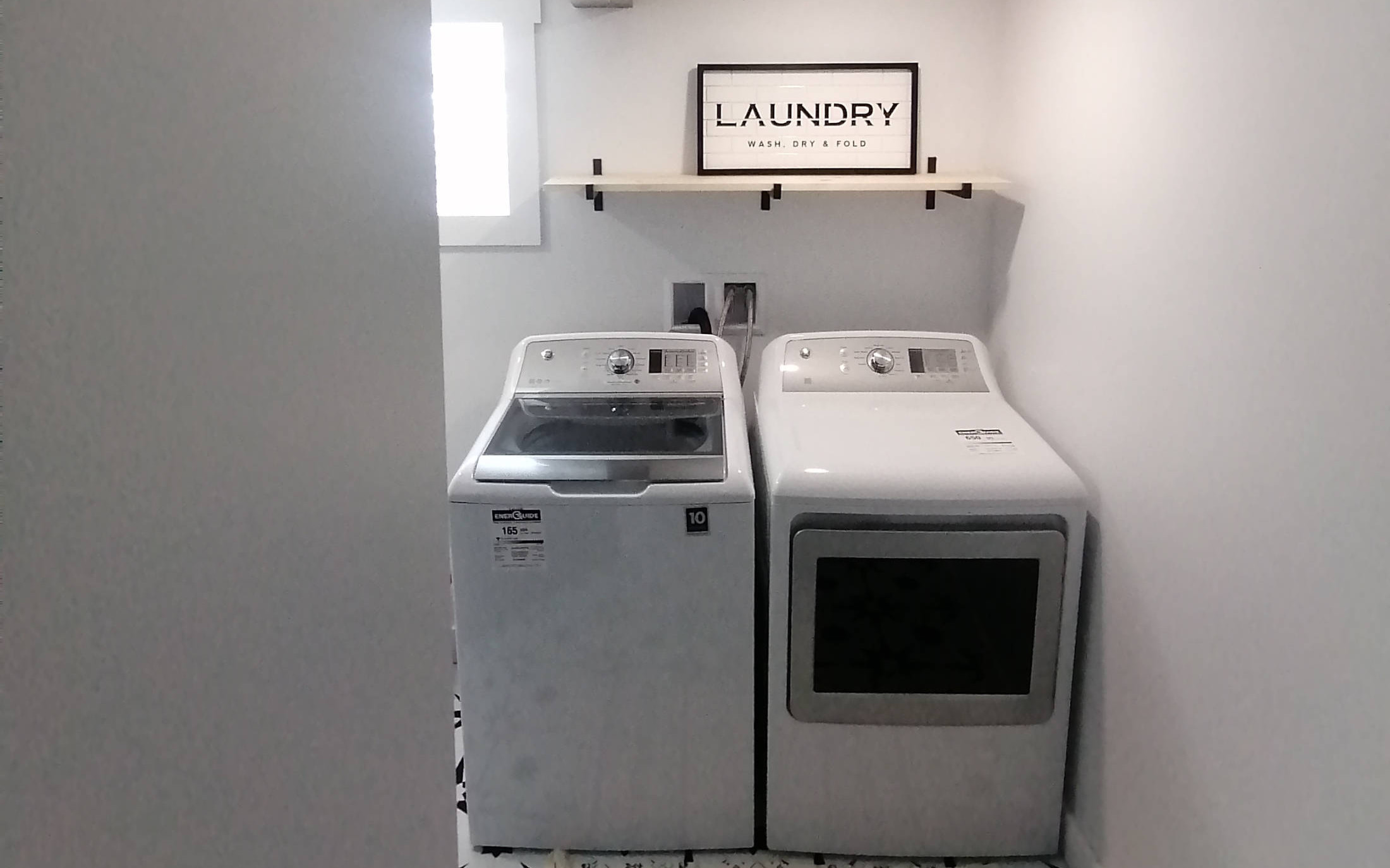 Laundry room with modern high end appliances and white accents - designed by Hint of Honey