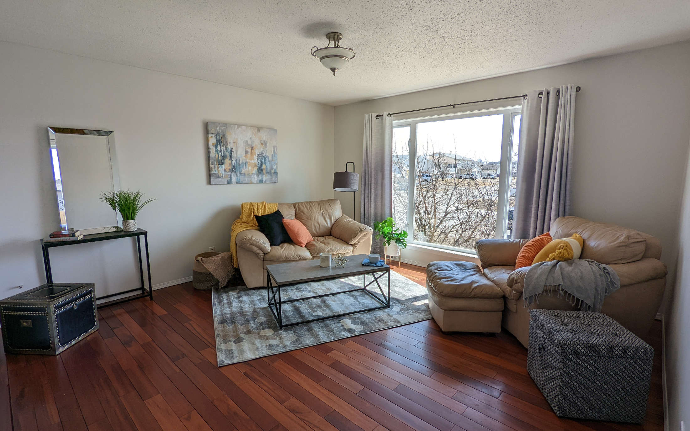 Staged living room with leather chairs and plush pillows - Hint of Honey