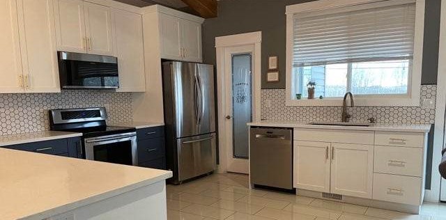 Modern kitchen with white tile backsplash and blue accents - Hint of Honey Fort St John