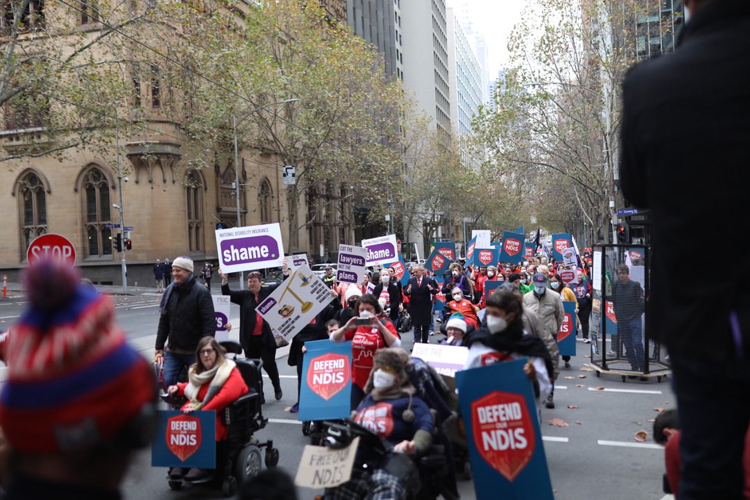 A large group of advocates march in Melbourne's CBD as part of the Every Australian Counts Defend our NDIS campaign. 