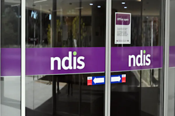 Image shows: The National Disability Insurance Scheme NDIS logo on the doors of the head office in Canberra.